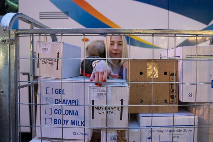 Una voluntaria de la Fundación Madrina coloca las cajas con el material donado para el convoy.