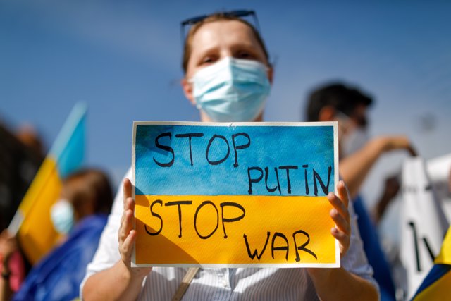 24 February 2022, Chile, Santiago: A demonstrator holds a placard reads "Stop Putin - Stop War," during a rally outside the Russian Embassy against the Russian invasion of Ukraine. Photo: Marcos Zegers/Agencia Uno/dpa