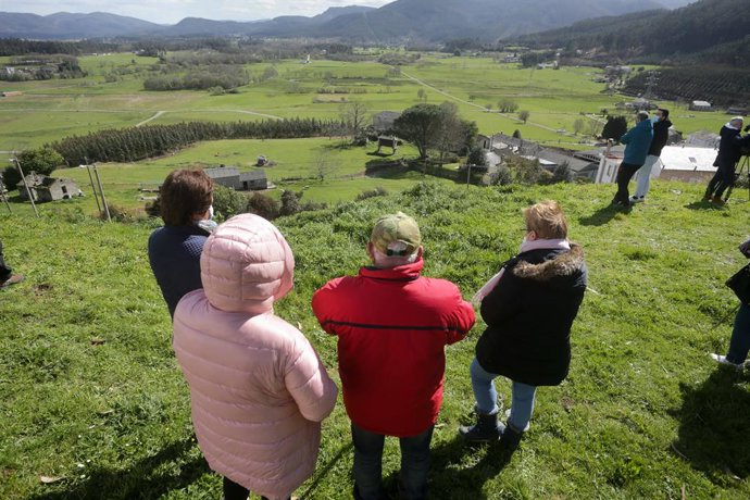 Varias personas observan los terreros donde tiene previsto construirse la balsa la futura balsa de la macrocentral hidroeléctrica al finalizar la manifestación para rechazar su instalación, a 13 de marzo de 2022,  O Valadouro, Lugo, Galicia, (España). L