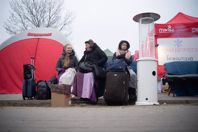13 March 2022, Poland, Medyka: (L-R) Anastasia, her mother Alla, who fled Sumy, sit next to Vira from Lviv shortly after crossing the borders from Ukraine to Poland. Photo: Sebastian Gollnow/dpa