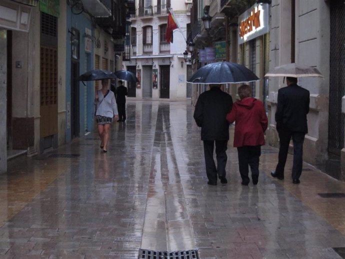Archivo - Imagen de archivo de personas con paraguas en Málaga