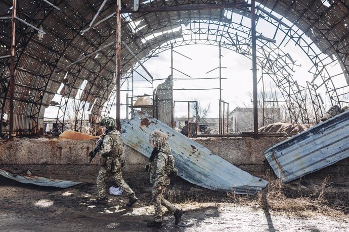 Dos soldados, del ejército ucraniano, caminan por una antigua fábrica destruida por la guerra en la línea del frente, a 19 de febrero de 2022, en Avdiivka, Oblast de Donetsk (Ucrania). Las autoridades de las autoproclamadas repúblicas de Donetsk y Lugan