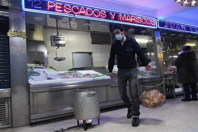 Archivo - Un pescadero traslada el marisco en una pescadería 