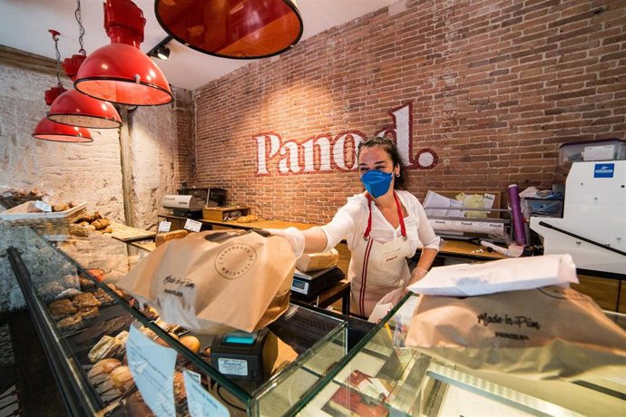 Archivo - Una trabajadora de la panadería Panod atiende a un cliente, en Madrid (España).