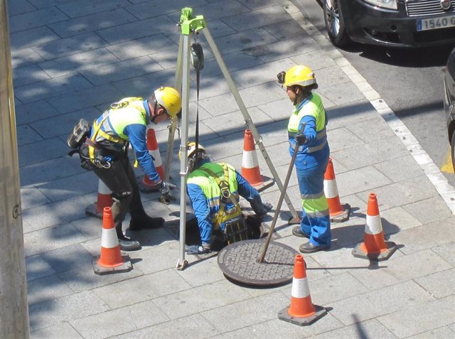 Archivo - Varios trabajadores inspeccionan un alcantarillado