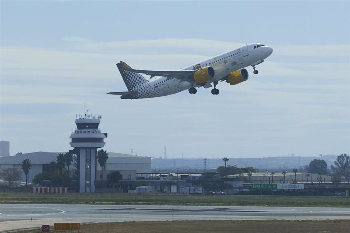 Un avión despega con la torre de control al fondo, en una imagen de archivo.