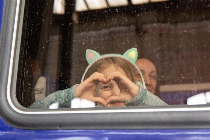 12 de marzo de 2022, Lviv, Ucrania: Un niño muestra una señal de corazón a través de la ventanilla de un tren hacia Polonia