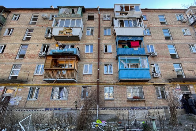 18 March 2022, Ukraine, Kiev: A woman looks from a balcony on the second floor of a damaged 5-storey residence destroyed by Russian shelling. Photo: Daniel Ceng Shou-Yi/ZUMA Press Wire/dpa