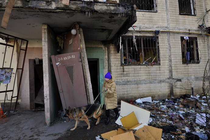 14 March 2022, Ukraine, Kiev: A woman seen with her dog near the apartment building that was shelled by the Russian army. Photo: Sergei Chuzavkov/SOPA Images via ZUMA Press Wire/dpa