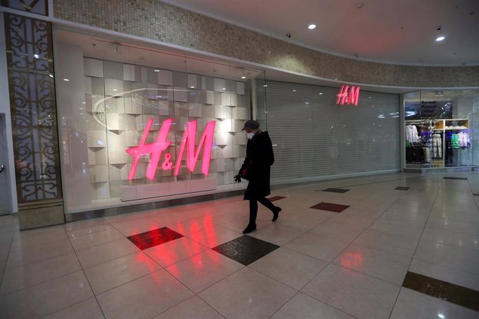 03 March 2022, Russia, St. Petersburg: A woman walks past a closed H&M in a shopping center in St. Petersburg. Swedish fashion giant H&M suspends its sales operations in Russia until further notice in light of the Ukraine war. Photo: Igor Russak/dpa
