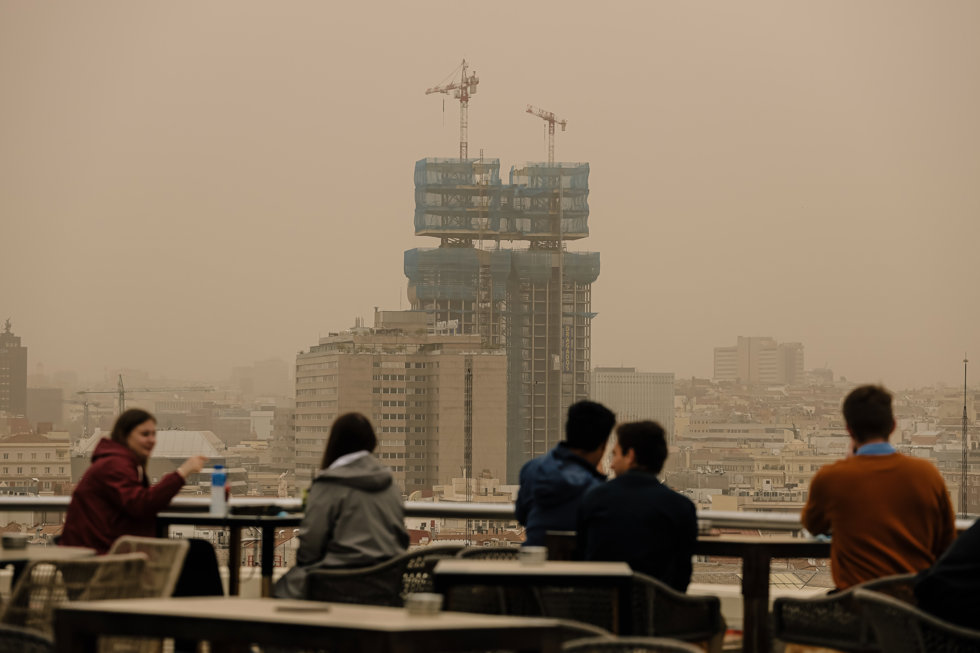 Varias personas observan la calima desde la terraza del Círculo de Bellas Artes, a 15 de marzo de 2022, en Madrid (España).
