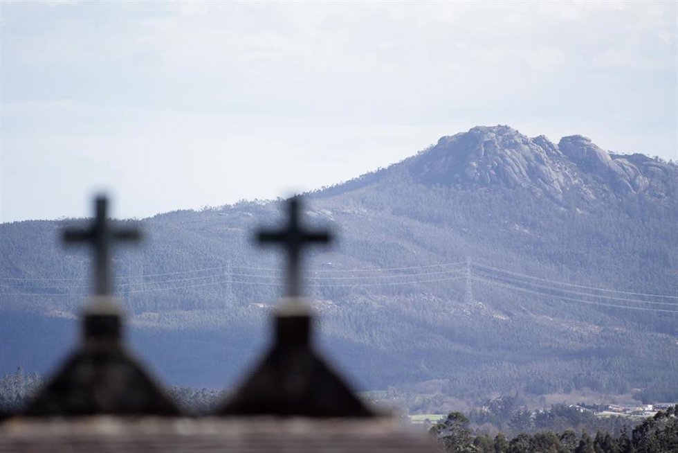 Dos cruces y de fondo los montes de la Serra do Xistral.