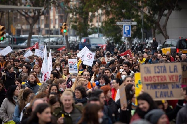 Manifestants sostenen pancartes i cartells a la manifestació durant el primer dia de vaga educativa a Catalunya.
