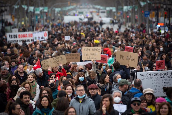 Manifestants sostenen cartells i pancartes en la manifestació durant el primer dia de vaga educativa a Catalunya, als Jardinets de Grcia