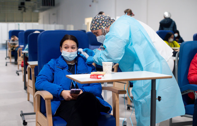 Un trabajador sanitario revisa a una persona procedente de Ucrania en las instalaciones del Hospital Enfermera Isabel Zendal, a 15 de marzo de 2022, en Madrid (España). 