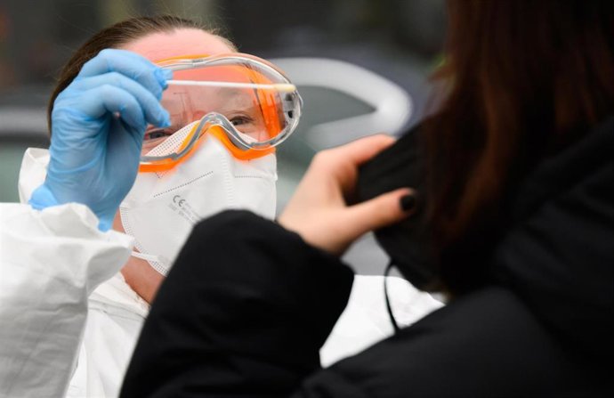 Archivo - 26 January 2022, Lower Saxony, Laatzen: A family doctor takes a swab sample from a person to perform PCR test coronavirus outside a doctor's office in the Hannover region. Photo: Julian Stratenschulte/dpa