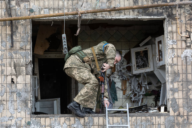 14 March 2022, Ukraine, Kiev: A soldier comes out of a badly damaged residential building that was hit by a Russian shell. Photo: Mikhail Palinchak/SOPA Images via ZUMA Press Wire/dpa