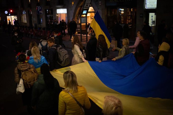 Un grupo de personas sostienen la bandera de Ucrania en una concentración ante la embajada rusa en Barcelona tras los primeros ataques rusos registrados en Ucrania esta pasada madrugada, a 24 de febrero de 2022, en Barcelona, Cataluña (España).