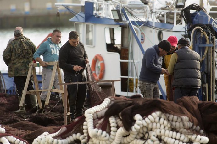 Varios pescadores en un barco en el puerto de Celeiro, a 8 de marzo de 2022, en Viveiro, Lugo, Galicia (España). La flota de Celeiro, en el municipio lucense de Viveiro, ha iniciado un amarre parcial debido a la subida del precio del gasoil derivada de 