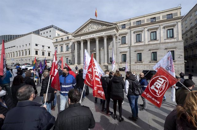 Varias personas con banderas de los sindicatos del comité de empresa de Metro de Madrid, participan en una concentración frente al Congreso de los Diputados.