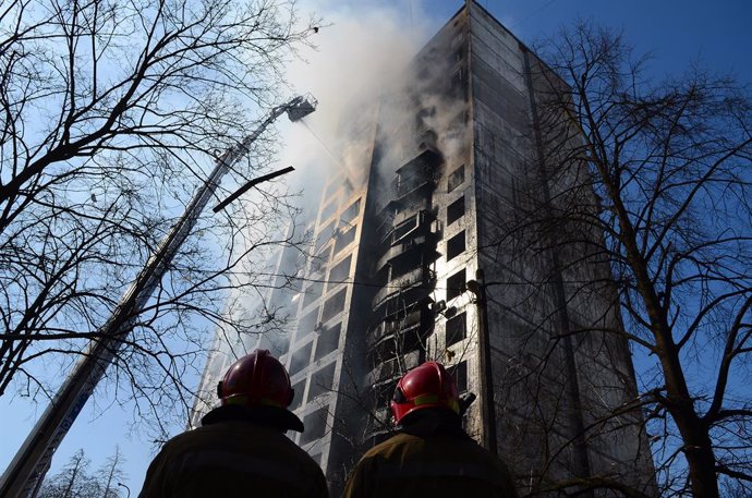 15 March 2022, Ukraine, Kiev: Firefighters stand in front of a burning residential building in the Svyatoshyn district, which was destroyead by bombardment. Photo: -/Ukrinform/dpa