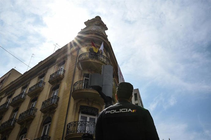 Archivo - Un agente de policía nacional observa la fachada de un edificio okupado 