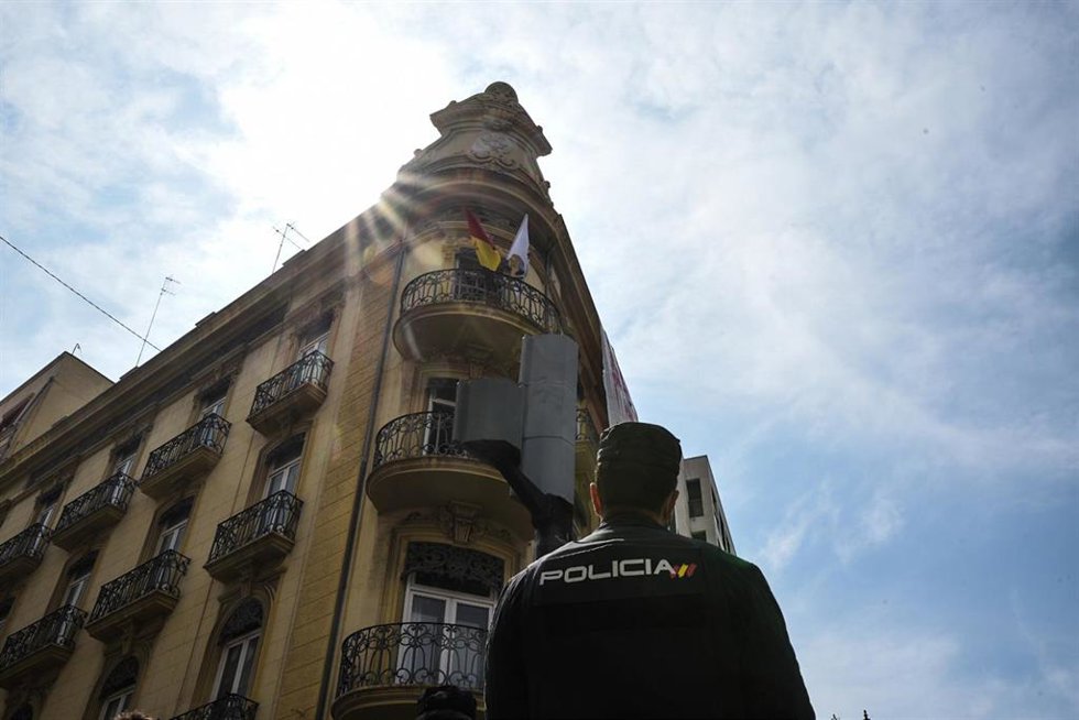 Archivo - Un agente de policía nacional observa la fachada de un edificio okupado 