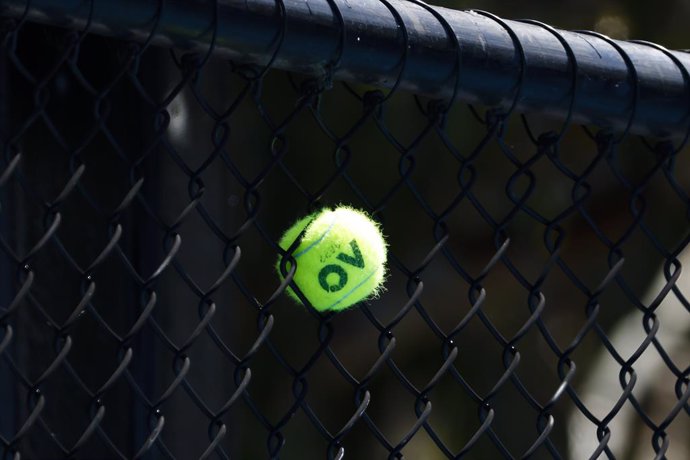 Archivo - 17 January 2022, Australia, Melbourne: A tennis ball is stuck between the meshes of a fence on Day 1 of the 2022 Australian Open at Melbourne Park. Photo: Frank Molter/dpa