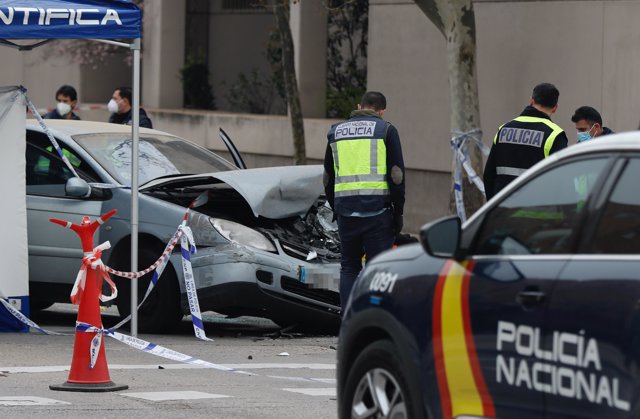 Varios agentes de Policía Nacional frente al vehículo en el que su único ocupante ha fallecido tras ser tiroteado desde otro vehículo, en la plaza de Alsacia, en el distrito de San Blas-Canillejas