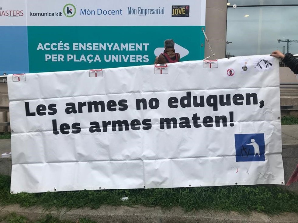 Pancarta de Desmilitaritzem l'Educació en el Saló de l'Ensenyament