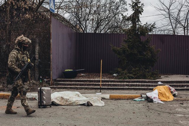 Ucrania condena el bombardeo teatral de Mariupol, que servía de refugio "cientos" De la gente Un soldado pasa junto a los cuerpos de dos civiles.