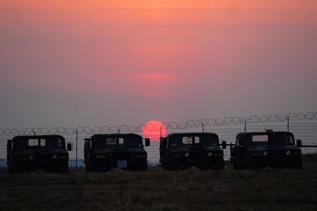 16 March 2022, Poland, Medyka: Military vehicles parked at Rzeszow airport while the sun sets behind them. Photo: Victoria Jones/PA Wire/dpa