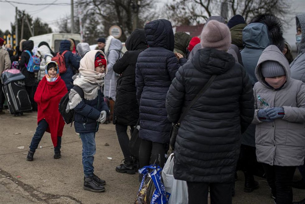 Varias personas y niños, esperan para cruzar a Rumanía, en el paso fronterizo de Porubne, a 5 de marzo de 2022, en el oeste de Ucrania.  