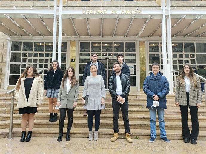 La consejera, Maru Díaz, junto a ocho beneficiarios de las becas.