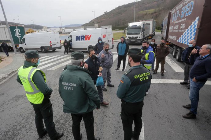 Camioneros parados en Pedrafita do Cebreiro negocian con varios agentes de la Guardia Civil su escolta hasta sus respectivos destinos, durante el cuarto día de paros en el sector de los transportes, a 17 de marzo de 2022, en Pedrafita do Cebreiro, Lugo,