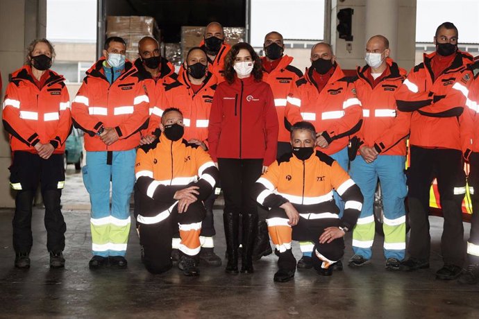 La presidenta de la Comunidad de Madrid, Isabel Díaz Ayuso (c), posa con los bomberos durante su visita al Parque de Bomberos de Las Rozas, a 14 de marzo de 2022, en Las Rozas, Madrid (España). Ayuso asiste a la salida de un camión cargado con material 