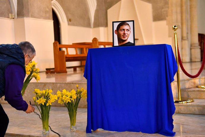Archivo - 21 January 2020, England, Cardiff: A man places flowers infront of a portrait of Emiliano Sala during a service at St David's Cathedral to mark a year since a plane carrying North Lincolnshire pilot David Ibbotson and Cardiff City footballer E