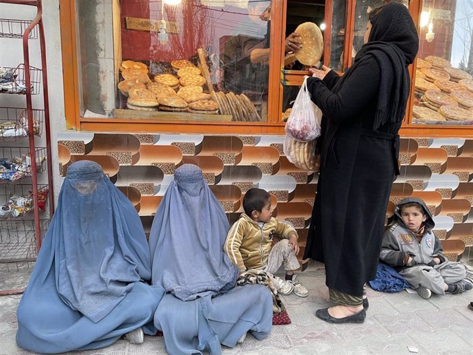 Un grupo de personas pide a las puertas de una panadería en Kabul.