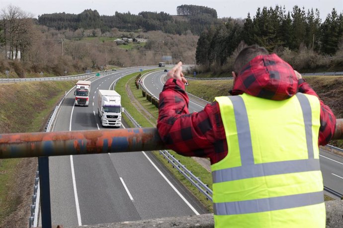 Un miembro de un piquete insulta y hace gestos a los camiones que pasan en dirección A Coruña escoltados por la Guardia Civil, durante el cuarto día de paros en el sector de los transportes, a 17 de marzo de 2022, en Baralla, Lugo, Galicia (España). Los