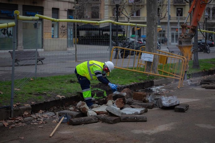 Un obrero y una máquina excavadora (archivo)