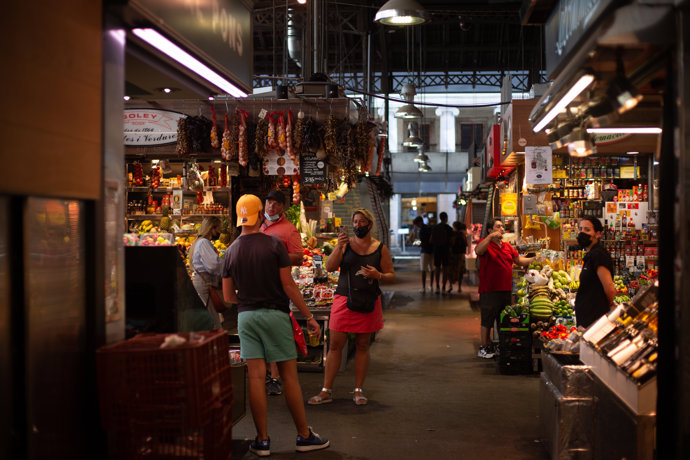 Una mujer hace una foto a un joven en el mercado de La BoquerIa, a 5 de agosto de 2021, en Barcelona, Cataluña, (España).  