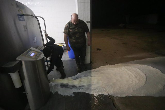 Un ganadero vierte la leche al suelo después de que la industria láctea tenga que parar su actividad a partir de hoy, a 17 de marzo de 2022, en Lugo, Galicia (España). 