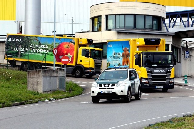 Coche de la Guardia Civil escoltando a camiones en el centro de Alimerka