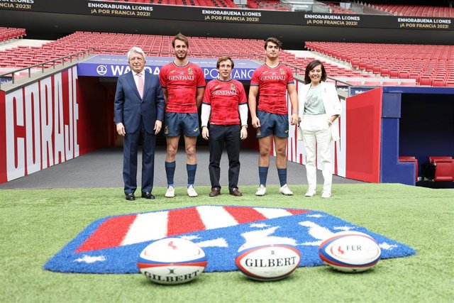 El presidente del Atlético de Madrid, Enrique Cerezo, el alcalde de Madrid, José Luis Martínez Almeida, y la CEO de Kiwihouse, Mirella Ruiz, posan junto a varios jugadores en la presentación del partido ante los Classic All Blacks en el Wanda.