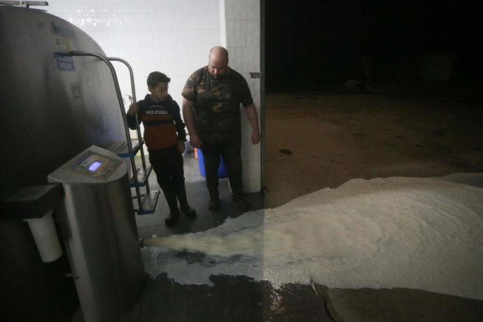 Un ganadero vierte la leche al suelo después de que la industria láctea tenga que parar su actividad a partir de hoy, a 17 de marzo de 2022, en Lugo, Galicia (España). 