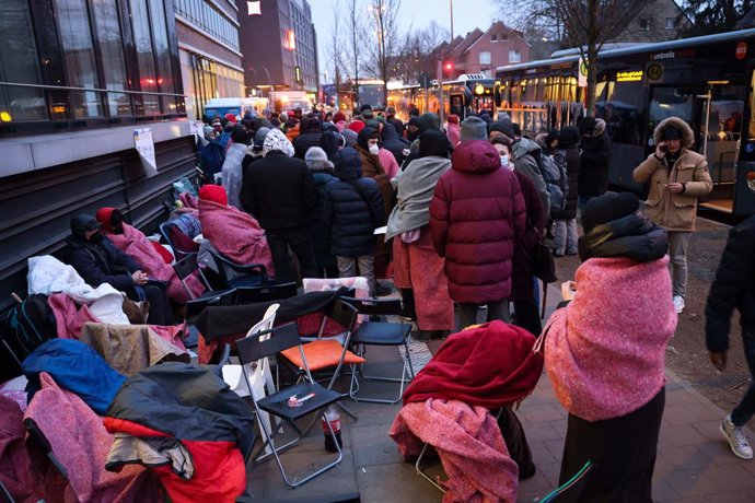 17 March 2022, Hamburg: People who have fled Ukraine wait wait for registration in front of the Office for Migration in Hamburg in the early morning. Photo: Christian Charisius/dpa