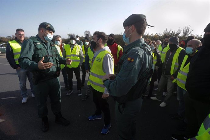 Dos agentes de la Guardia Civil hablan con los miembros de un piquete que han cortado la A-6 en ambos sentidos a la altura de Guitiriz, en Lugo