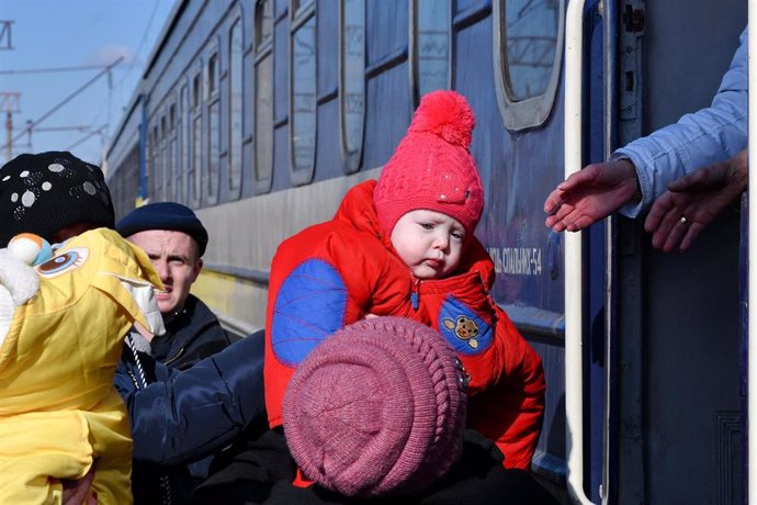 Una mujer ayuda a un niño a subir a un tren en Kramatorsk, Ucrania.
