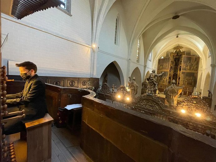 El organista titular de la Iglesia de San Pablo de Zaragoza, Carlos González Martínez, y, al fondo, las puertas del retablo mayor abiertas.