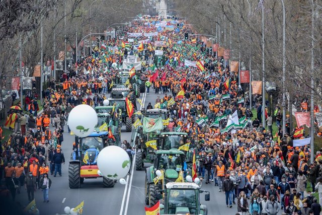 Varios tractores y  manifestantes con pancartas, bandera, durante la marcha ‘20M’, a 20 de marzo de 2022, en Madrid (España). 